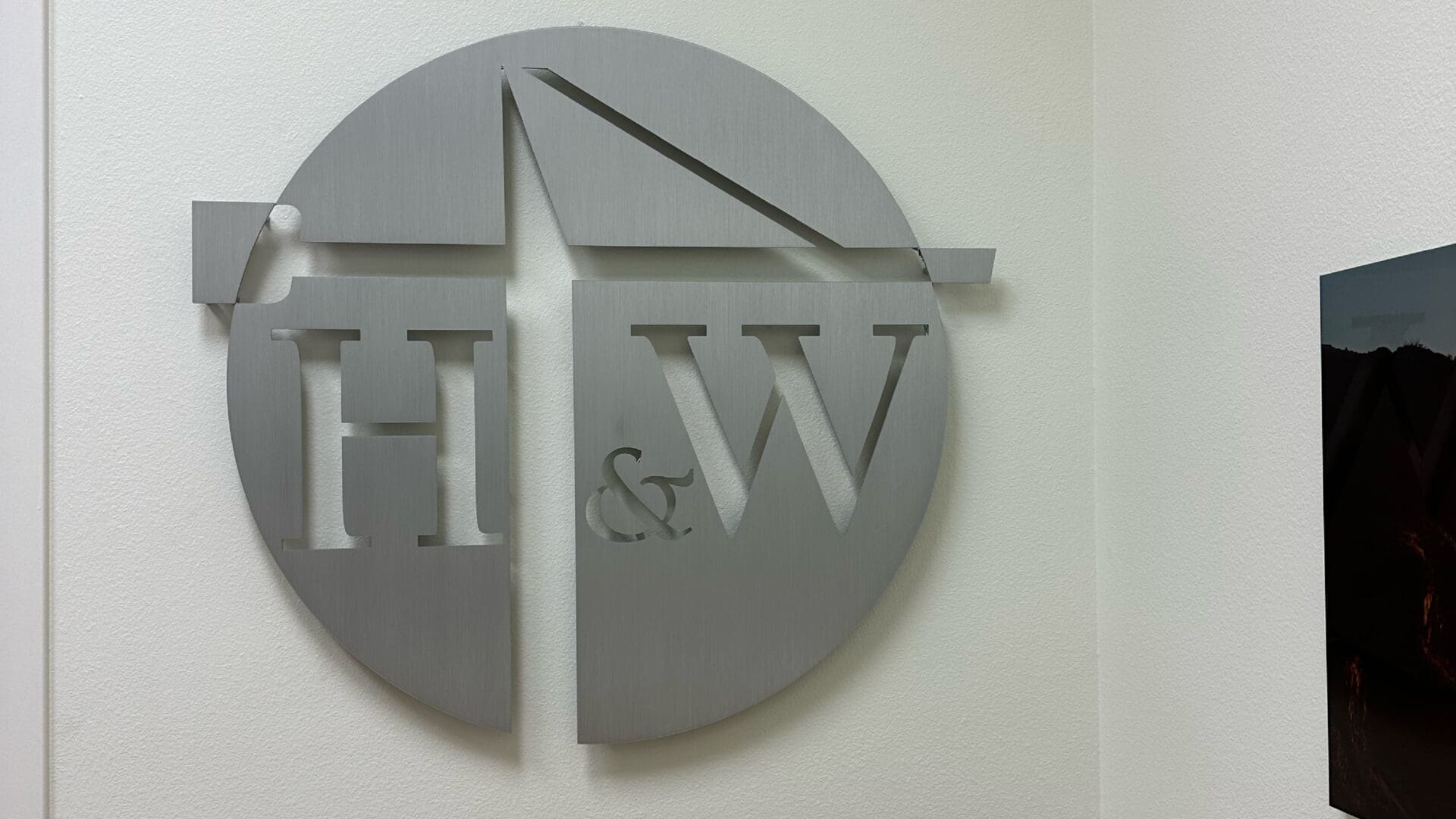 Minimalist stainless logo mounted on white wall