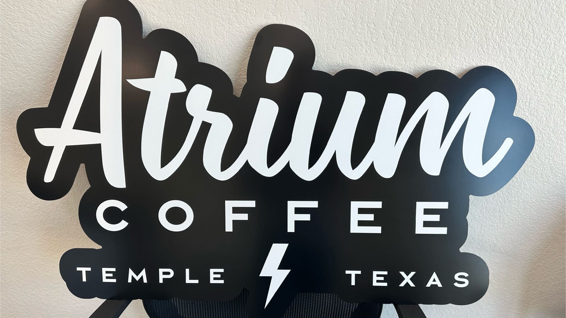 Atrium Coffee black wall sign with lightning bolt