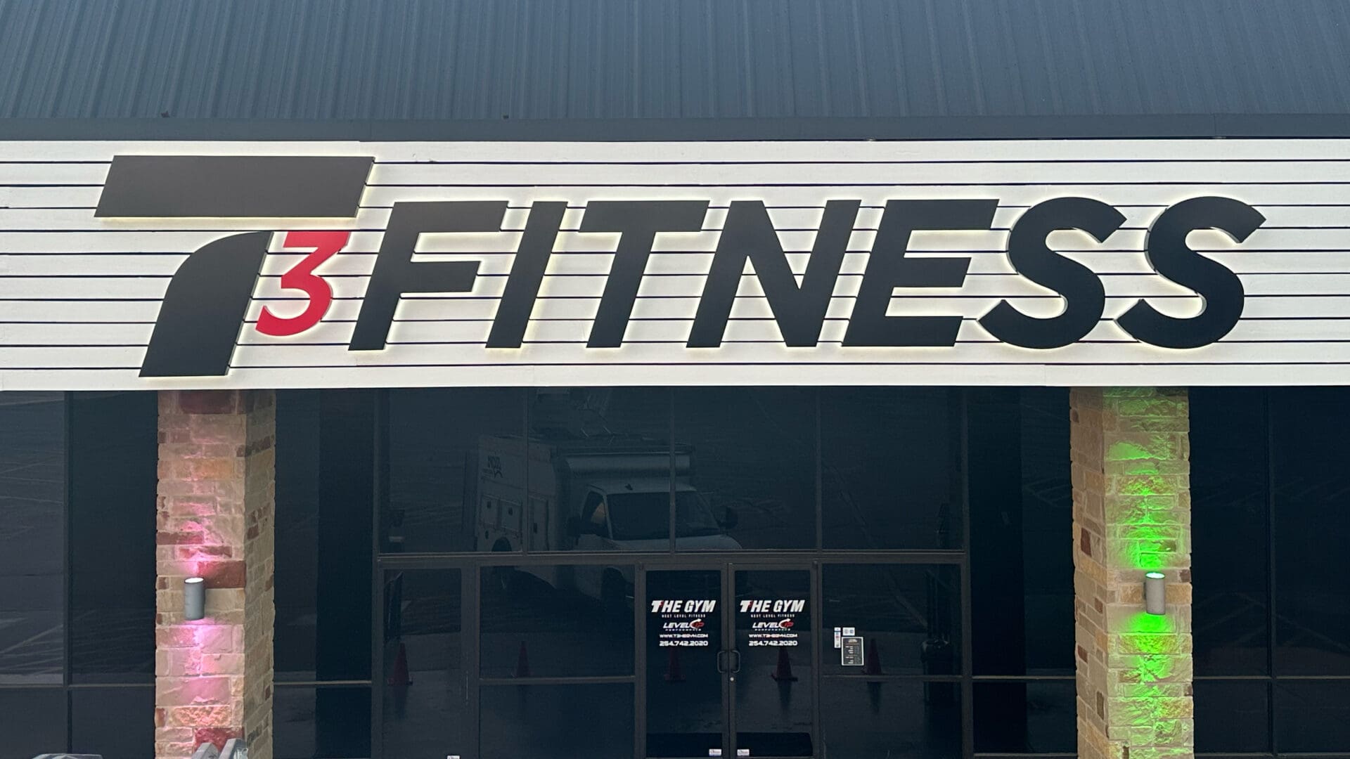 Large exterior FITNESS sign above entrance